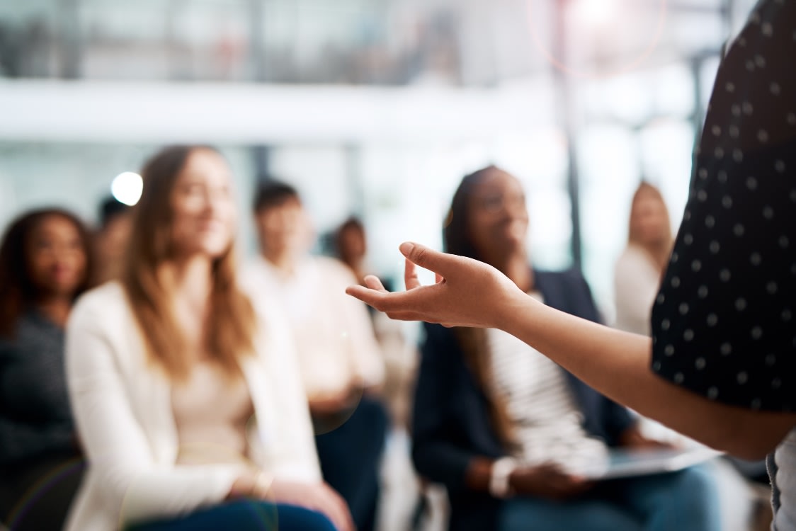 A group of people sitting and listening to a speaker